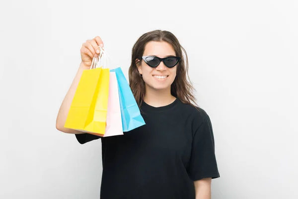 Agradable joven mujer está sosteniendo algunas bolsas de compras sobre fondo blanco. —  Fotos de Stock