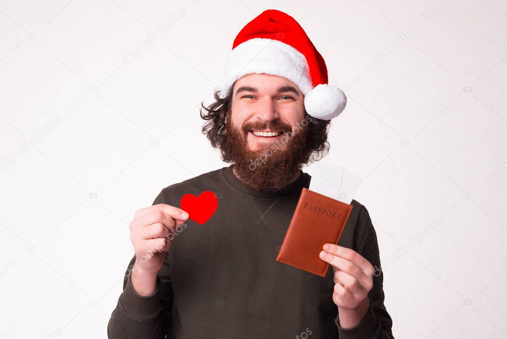 I just love traveling. Bearded man is holding his passport with tickets and heart shape.