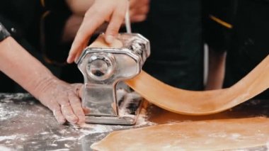 Mutfakta makarna ve lazanya için hamur hazırlayan şefin görüntüsü.