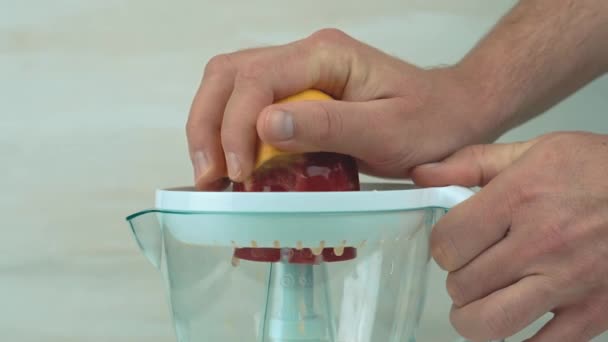 Imágenes de cerca de hacer jugo de naranja con exprimidor eléctrico — Vídeos de Stock