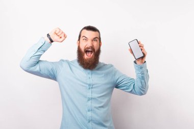 Sakallı adam elinde telefonuyla zaferi kutluyor..