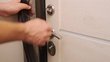 Çağdaş bir kapının kilidini parlak bir sapla açmanın ustalıkla kanıtlayan bir el.