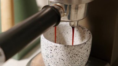 Espresso özümseme sanatını yakalıyorum. Zengin kahve kadehleri zarif bir şekilde benekli bir fincana akıyor.