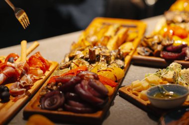 Kırsal ahşap heyet, kurutulmuş etler ve keskin turşular, karamelize edilmiş soğanlar ve kaba hardallı şef tatma istasyonu.,