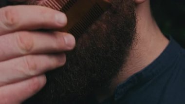 Yakın plan sakallı, tahta taraklı, kahverengi saçlı, titremeyen elli, donanma tasmalı, odaklı stil rutini, desenli...