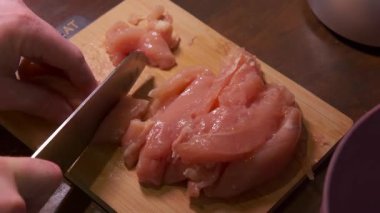 Tahta tahtadaki ince şeritlere dilimlenmiş çiğ tavuk, Öğrenci Aşçı Elleri Hızlı Kızartma, Bowling ve Utensiller İçin Malzemeleri Hazırlıyor