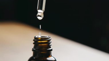 Yakın plan Düşüren Kehribar Şişesinin Üzerinde, Serum Düşürme Cam Şişeye Düşüyor, StüdyoLit Asgari Arkaplan, Yavaş Hareket