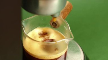 Espresso makinesini kapat Kremayı cam şişeye dök Tarçın çubuğuyla altın krema fırıl fırıl dönüyor,