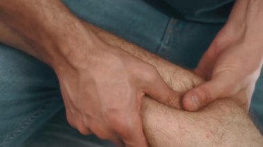 Yakın plan beyaz adam masaj yapan bacak kası, firma baskısı uygulayan eller ve postrun rahatlaması için baldırı kıran adam.