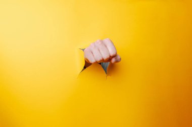 Sarı Arkaplanda Yumruk Kırma Kararlılık ve Dayanıklılık Taşıma, Yakından Gelen El