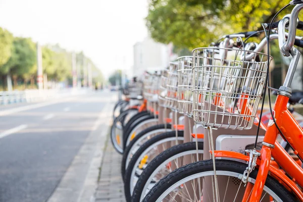 Reihe orangefarbener Leihfahrräder — Stockfoto