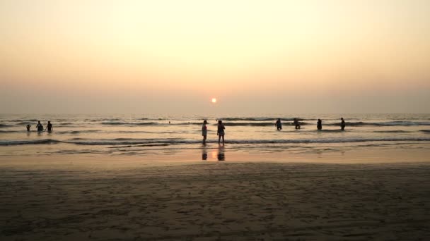 Personer i solnedgången havet. — Stockvideo