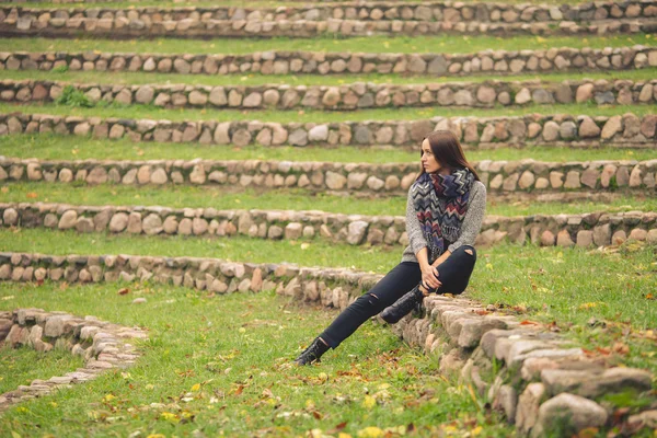 Mulher solitária sentada sozinha nas pedras para o jardim de outono — Fotografia de Stock