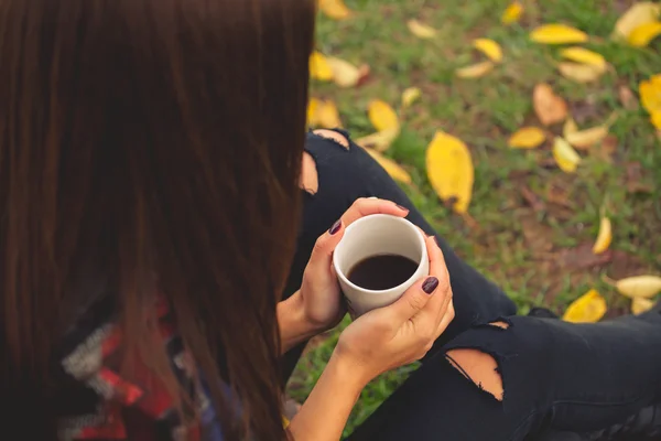 Dinlenme ve içme kahve sonbahar bahçede oturan güzel kız