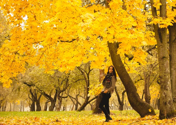 Mulher solitária tendo descanso sob a árvore perto da água em um dia nebuloso de outono. Mulher solitária desfrutando da paisagem da natureza no outono. Dia de outono . — Fotografia de Stock