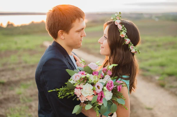 Genç bir çift aşık günbatımında günbatımı arka plan birbirine bakarak - açık