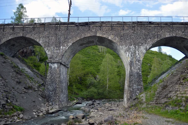 Ponte de pedra ferroviária através do rio da montanha — Fotografia de Stock