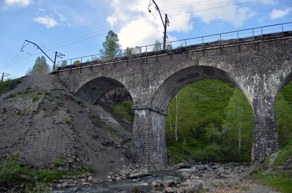 Puente ferroviario de piedra a través del río montaña — Foto de Stock