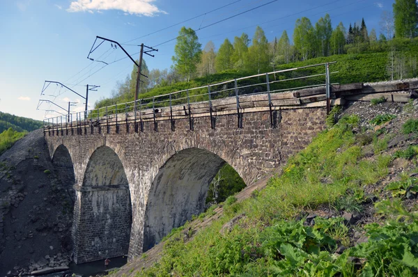 Ponte de pedra ferroviária através do rio da montanha — Fotografia de Stock