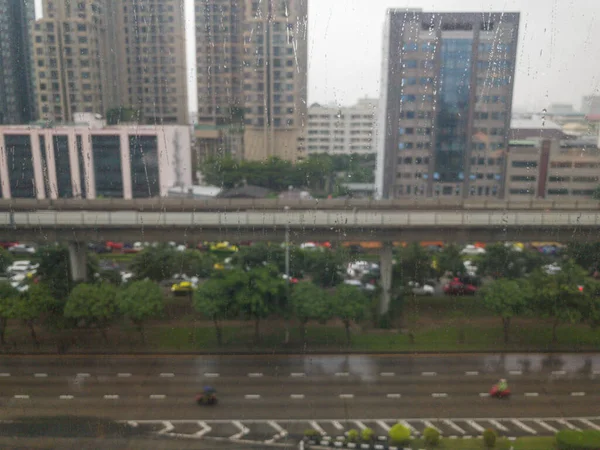 玻璃中的水滴和冰雹中的城市背景 — 图库照片