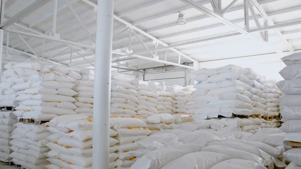 Bags with flour in warehouse of flour factory. Flour stock. Mill warehouse