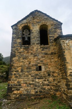 Orman tepeleri ve yeşilliklerle çevrili verimli bir kırsal alanda yenilenmekte olan Romen taş kilisesi.