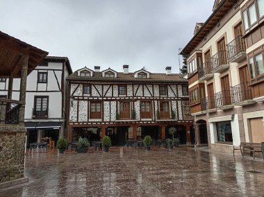 Tarihi mimarisi, ahşap çerçeveli evleri ve ıslak kaldırımı olan köy meydanı.