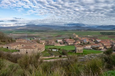 Dağların yakınındaki yeşil bir vadiye yerleşmiş kırmızı çatıları olan tarihi taş köyü.