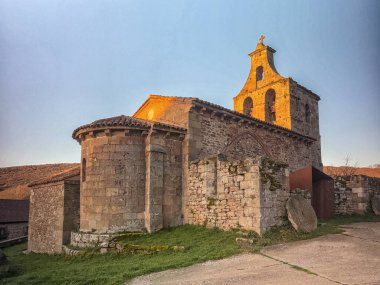 Günbatımında çan kulesi ve kemerli kapısı olan antik Romen taş kilisesi.