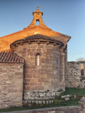 Günbatımında çan kulesi ve kemerli kapısı olan antik Romen taş kilisesi.
