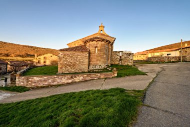 Günbatımında çan kulesi ve kemerli kapısı olan antik Romen taş kilisesi.