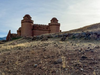 La Calahorra Kalesi 'nin tepesinde köy ve çam kaplı dağlara bakan bir tepe.