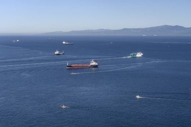 Cebelitarık Boğazı 'nı geçen birden fazla gemi berrak mavi gökyüzü ve sakin denizin altında.