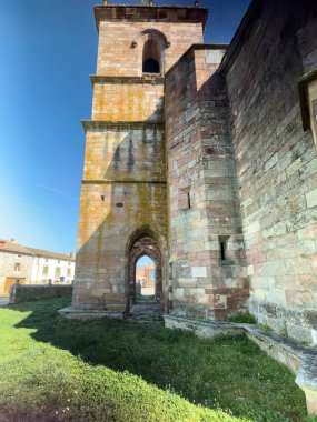 San Pelayo Kilisesi 'nin önü taş kuleyi ve gün ışığında kemerli girişi gösteriyor.