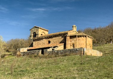 Taş duvarları, kırmızı fayanslı çatısı ve Palencia kırsalında kurulu çan kulesi olan tarihi Roma kilisesi..