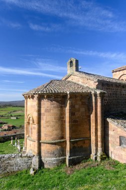Taş duvarları, kırmızı fayanslı çatısı ve Palencia kırsalında kurulu çan kulesi olan tarihi Roma kilisesi..