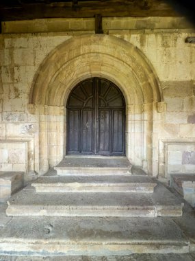 İspanya kırsalında çan kulesi ve bahçesi olan geleneksel taş kilise.