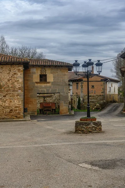 Palencia 'daki tarihi köy meydanında taştan evler ve klasik bir demir sokak lambası var..