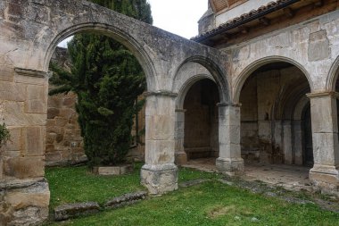 San Andres Kilisesi, İspanya 'daki eski taş kemer ve yeşil avlu manzarası.