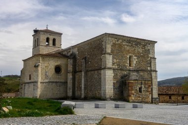 Kare çan kulesi ve Romanca mimari detayları olan eski taş kilise..