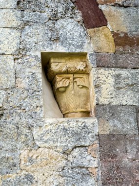 Eski kilise duvarında dekoratif motiflerle detaylandırılmış taş sermaye.