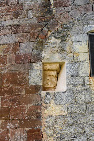 Eski kilise duvarında dekoratif motiflerle detaylandırılmış taş sermaye.