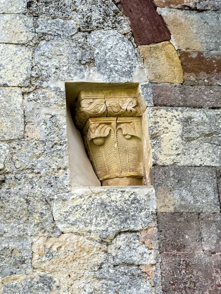 Eski kilise duvarında dekoratif motiflerle detaylandırılmış taş sermaye.