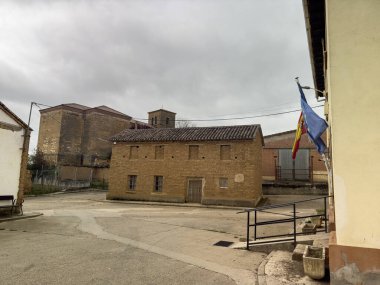 Kiremitli çatılı ve kırsal kesimdeki yeşil kapılı kır evi.