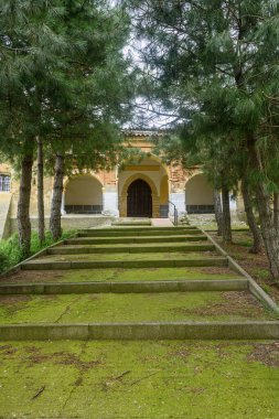 Çan kulesi ve kemerli verandalı taş ve tuğla kilise geniş bir merdiven tarafından erişilebilir.