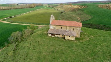 Quintanilla de Palencia yakınlarındaki açık kırsalda seramik çatılı taş kilise.