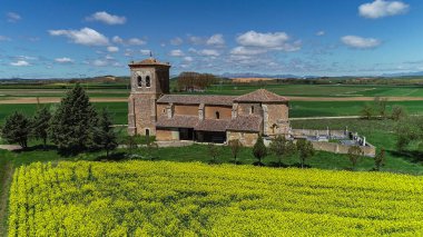 Paramo de Boedo 'daki taştan kilise. Yeşil kırsal alanda bir çan kulesi var.