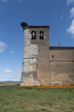 Calahorra de Boedo 'daki taş kilise. Çan kulesi ve leylek yuvası sessiz bir kırsal alanda.