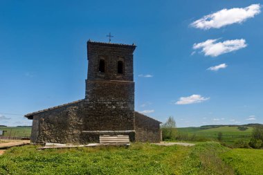 Palencia İspanya 'da çan kulesi ve terk edilmiş nesnelerle dolu eski taştan bir kilisenin kırsal manzarası.