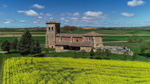 Paramo de Boedo 'daki taştan kilise. Yeşil kırsal alanda bir çan kulesi var.